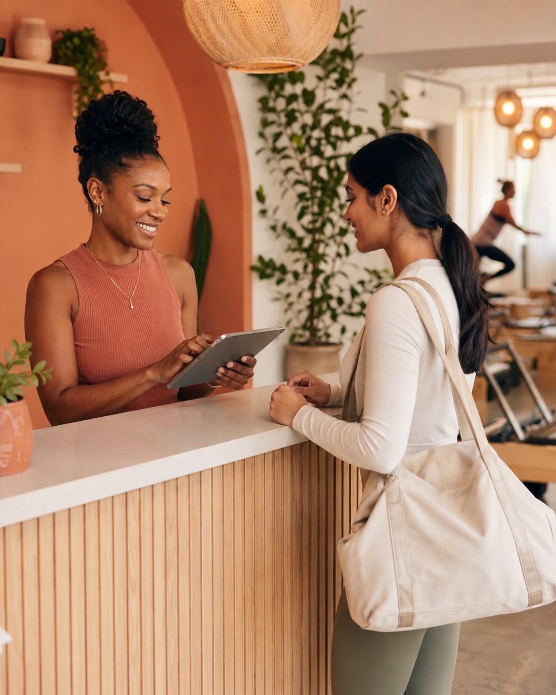 A studio owner checking a client in at the front desk.